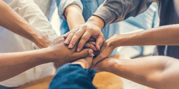 business people making pile of hands