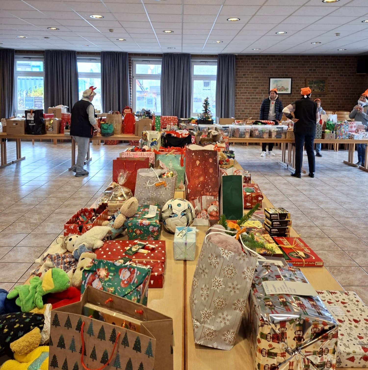Menschen mit freundlichen Gesichtern bereiten bunte Geschenke auf Tischen vor